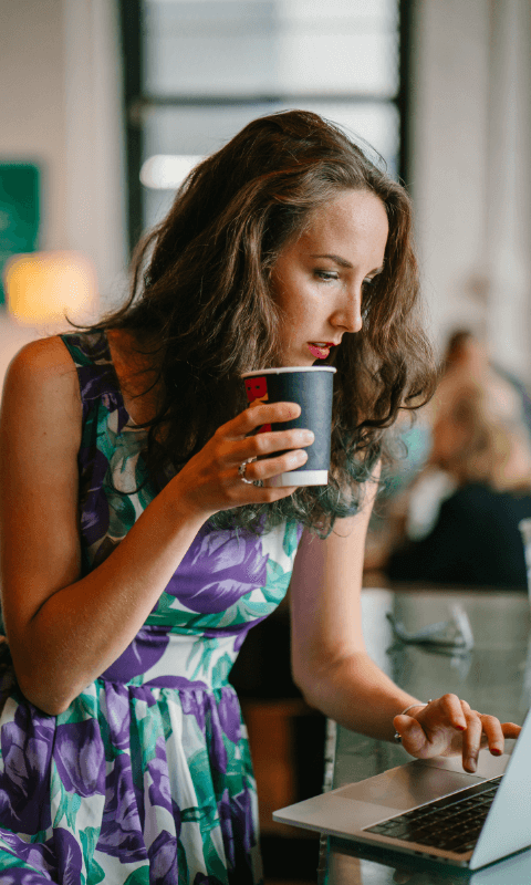 Woman drinking coffee checking email
